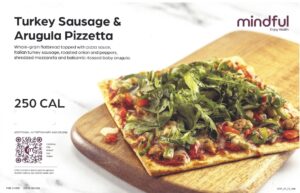 A promotional image for Mindful’s Turkey Sausage & Arugula Pizzetta. The dish is described as a whole-grain flatbread topped with pizza sauce, Italian turkey sausage, roasted onion and peppers, shredded mozzarella, and balsamic-tossed baby arugula. It contains 250 calories and includes allergens: milk, wheat, soy, and gluten. A QR code is present for more nutritional information and recipe.