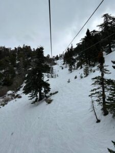 Image of ski lift and snowy slope with trees
